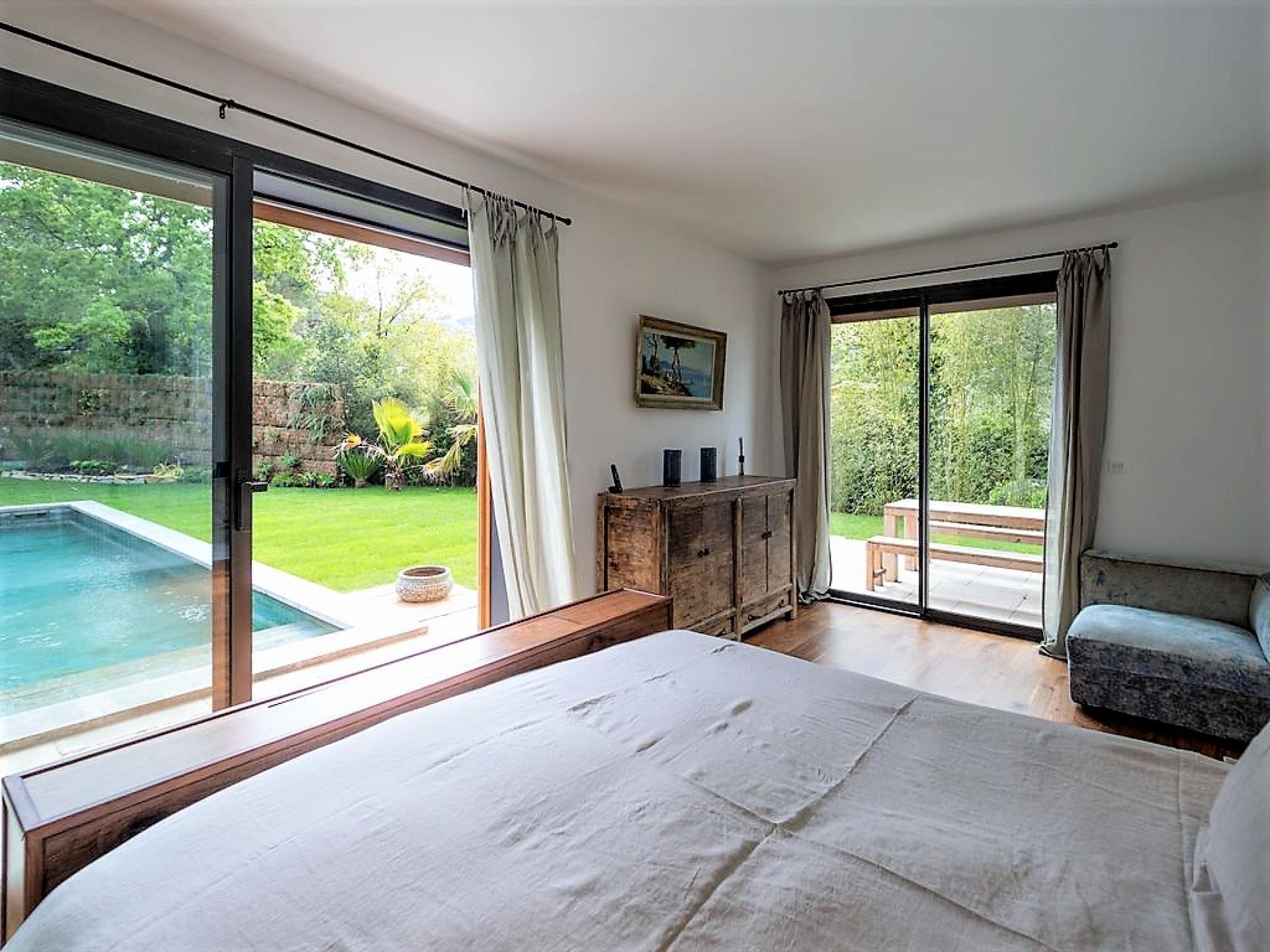THE BEDROOM WITH VIEW OF THE SWIMMING POOL IN VILLA DE LA PINEDE HOLIDAY RENTAL IN ST TROPEZ