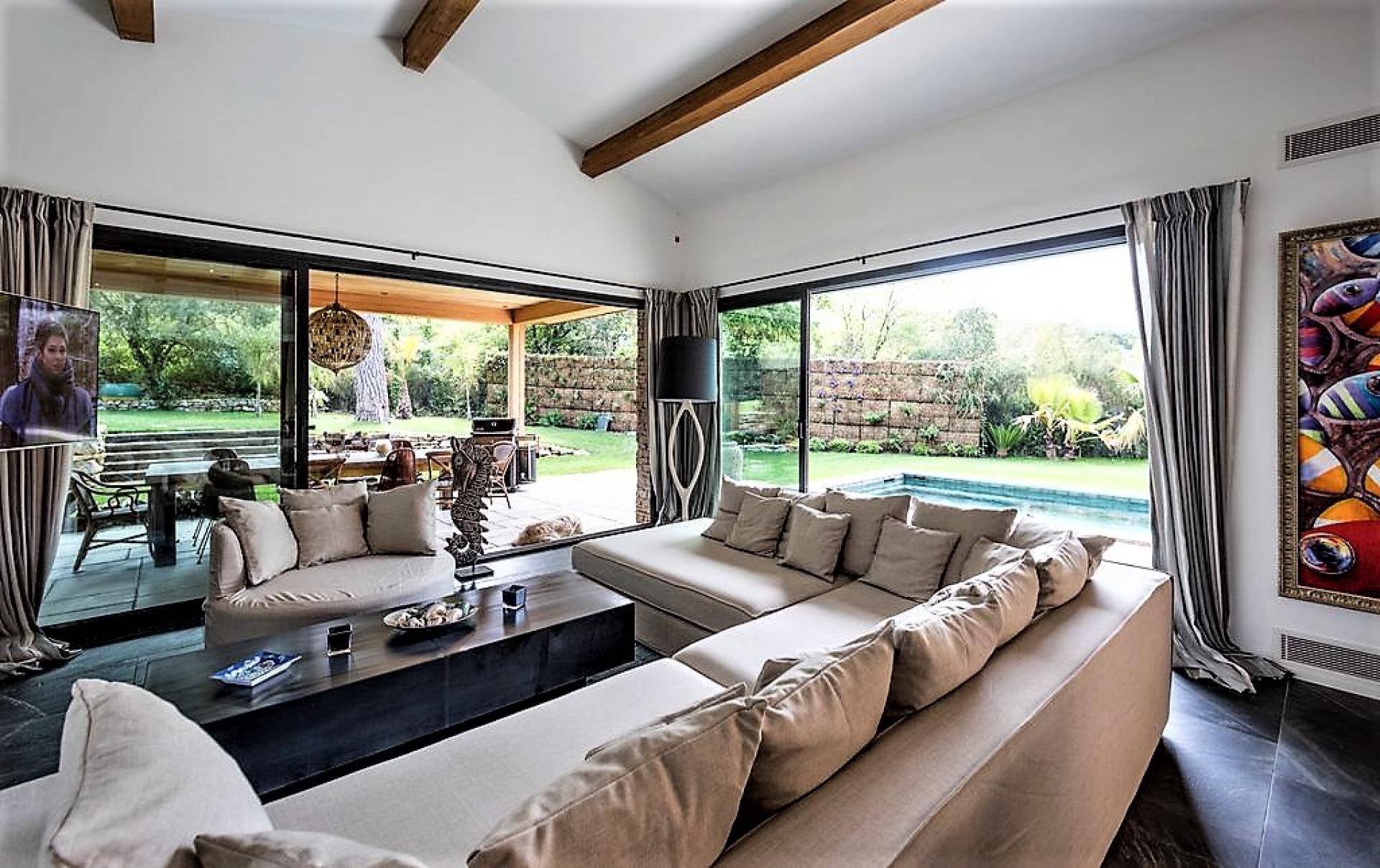 THE LIVING ROOM WITH VIEW ON THE SWIMMING POOL VILLA DE LA PINEDE HOLIDAY RENTAL ST TROPEZ